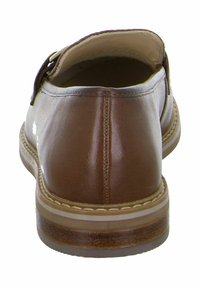 Brown leather shoe with a smooth finish, rounded back, and a low heel. Features a stitching detail along the sole and adjustable strap.