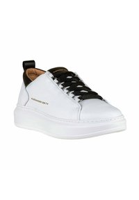 Baskets en cuir blanc avec talon et lacets noirs ; dotées d'un col rembourré, d'une semelle texturée et d'un logo embossé sur le côté.