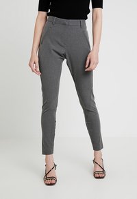 Pantalons gris sur mesure avec des jambes fuselées, poches avant et détails à la taille. Texture lisse, conçus pour une silhouette ajustée.
