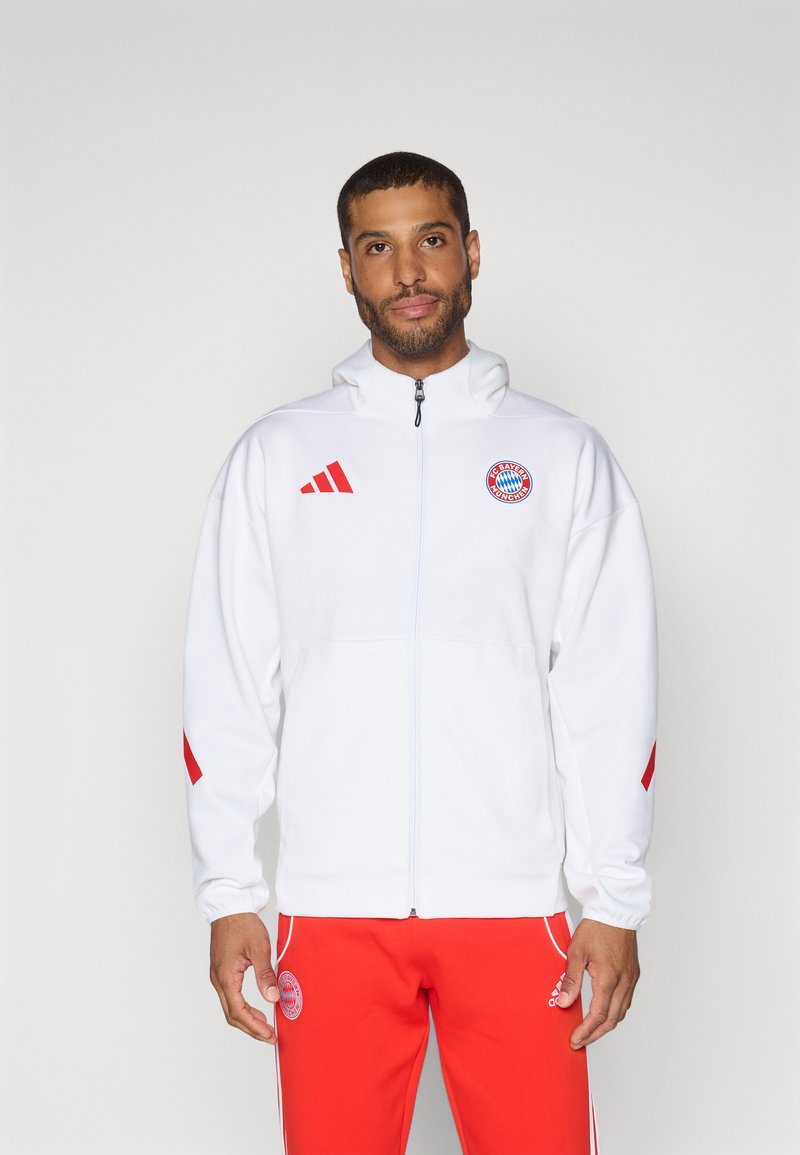 White zip-up jacket with red accents and Adidas logo, featuring a hood, ribbed cuffs, and Bayern Munich crest on the chest.