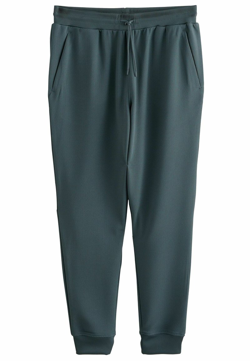 Donkergroene sportbroek van een gestructureerde stof, met een trekkoord in de taille en zijzakken. Gekraagde mouwen en een gladde oppervlakteafwerking.