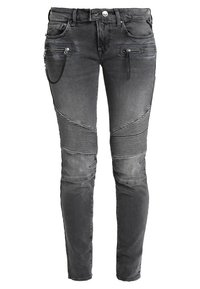 Jeans ajustados de color gris oscuro con paneles de rodilla acanalados, bolsillos frontales con cremallera, una cadena en el bolsillo izquierdo y detalles desgastados.