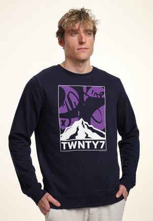 Marineblå sweatshirt lavet af bomuld, med et hvidt bjerggrafik og lilla detaljer. Ribbet rund hals og manchetter.
