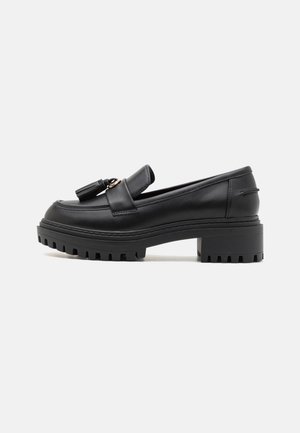 Mocassins en cuir noir avec un bout rond, détail de frange et semelle en caoutchouc épaisse dotée de profondes rainures pour une meilleure adhérence.
