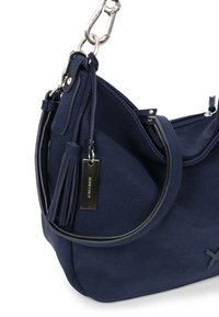 Marineblau strukturierte Schultertasche mit silbernem Verschluss, Quasten-Reißverschlussanhänger und rechteckigem Metallanhänger, der am Riemen hängt.