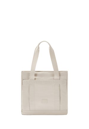 Bolso tote beige hecho de tela texturizada, con dos asas resistentes, bolsillos laterales y una etiqueta de logo. Forma rectangular con bordes reforzados.