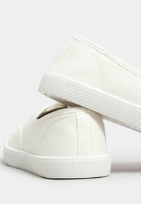 Scarpe slip-on bianche in tela con tessuto testurizzato, punta arrotondata e suola in gomma con battistrada strutturato per una migliore aderenza.
