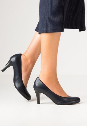Zwarte leren hoge hakken met een ronde neus en een slank ontwerp. Heeft een gematigde hakhoogte en een gladde, glanzende textuur.