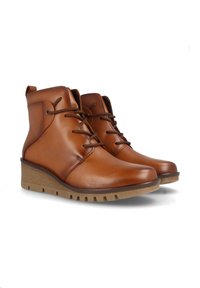 Botas de tobillo de cuero marrón con diseño de cordones, que cuentan con una suela de cuña texturada y punta redondeada. Detalles de costura sutil en los laterales.