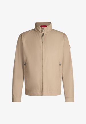 Beige Reißverschlussjacke mit hohem Kragen, Druckknöpfen und zwei seitlichen Reißverschlusstaschen vor weißem Hintergrund.