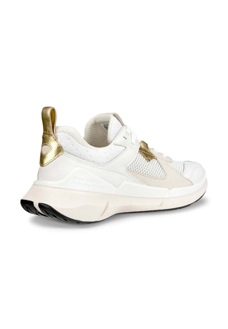 Witte sportschoen met bovenwerk van mesh, gouden accenten en een zachte roze zool. Heeft een geperforeerde textuur en opvallende branding aan de zijkant.