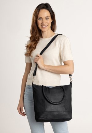 Black leather tote bag with shoulder strap, featuring a smooth texture, rounded handle, and a structured, rectangular design.