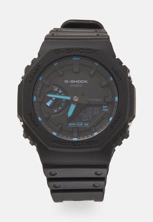 Schwarze G-Shock-Uhr mit digitalem Display, blauen Akzenten, strukturierter runder Zifferblatt und einem matten Gummiband, ausgestattet mit Druckknöpfen und schützendem Gehäuse.