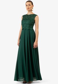 Lange groene jurk met een kanten lijfje dat ingewikkelde bloemmotieven vertoont, een vloeiende chiffon rok en een gegolfde zoom, ontworpen voor formele gelegenheden.