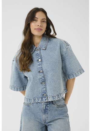 Short-sleeve denim jacket in light blue with a button front, collar, and cropped hem. Features subtle fading and contrast stitching details.