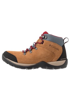 Bota de senderismo impermeable Columbia en color marrón claro y gris, con cordones rojos y suela de goma negra, diseñada para uso en exteriores y soporte para el tobillo.