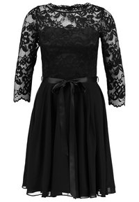 Svart klänning med långa spetsärmar, en skräddarsydd spetskjol och en flödande kjol. Har ett satinbälte knutet i midjan. Klassisk design.