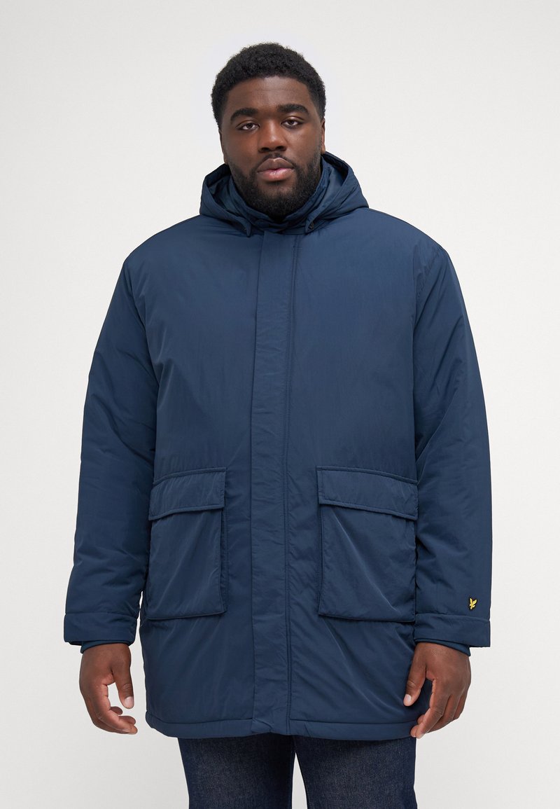 Cappotto imbottito blu navy con cappuccio, dotato di due tasche frontali e polsini elasticizzati. Realizzato in materiale liscio e leggero con chiusura a zip.
