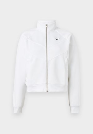 Hvit zip-up jakke med høy krage, geometrisk paneldesign og en liten svart logo på venstre bryst. Mykt stoff, tettsittende mansjetter.