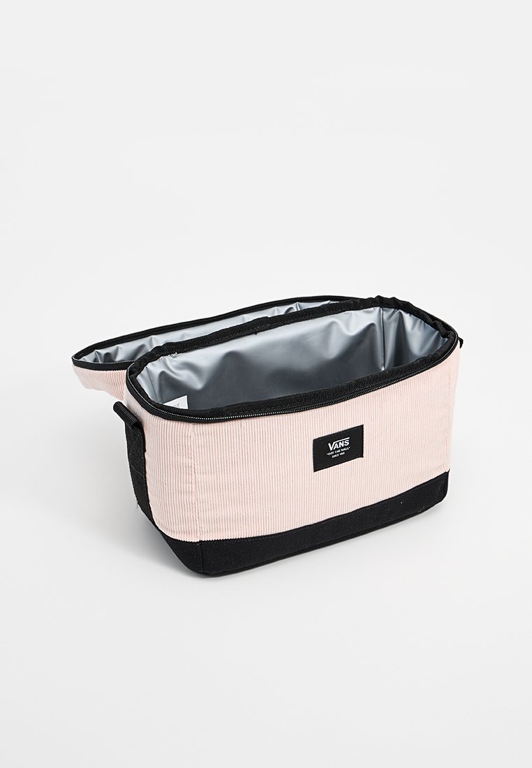 Neceser de corduroy rosa con base negra e interior plateado. Presenta cierre de cremallera y etiqueta del logo de Vans en el lateral. Forma rectangular.