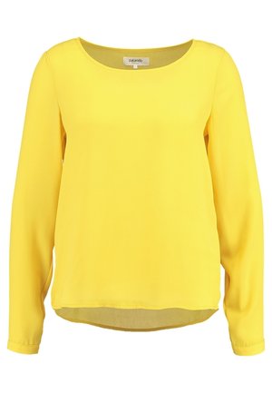 Żółta, gładka bluzka z długim rękawem, okrągłym dekoltem, lekko zaokrąglonym dołem i metką Zalando wewnątrz kołnierza.