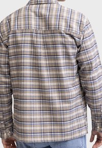 Hnědá a modrá kostkovaná košile s dlouhými rukávy, knoflíkovými manžetami, rovný lem a měkkou texturovanou látkou. Výrazný design zadní části.