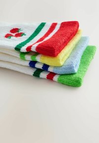 Colorful cotton socks stacked neatly: white with red, green and blue stripes; pastel yellow; blue; and green textures visible.
