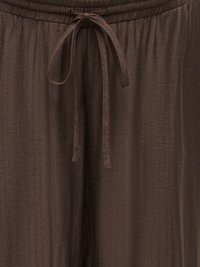Pantalon ample en tissu marron avec une ceinture élastique et un cordon noué au centre devant.