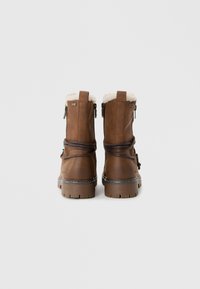 Bruine leren boots met een nepbontvoering, zijkant ritsen en gevlochten accenten. Dik rubberen zolen voor grip. Minimalistisch ontwerp.