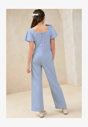 Salopetă de culoare albastru deschis cu mâneci scurte, evazate și spate pătrat, având închidere cu fermoar și un design cu picior larg. Accentuată cu detalii de fundițe plate.