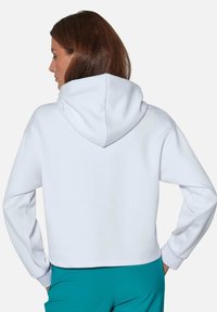 Witte cropped hoodie met een trekkoord capuchon, lange mouwen en geribde manchetten. Zachte stof met een gladde textuur. Achteraanzicht getoond.