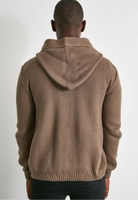 Felpa con cappuccio marrone a maglia con un design testurizzato e a trama aperta. Presenta un cappuccio ampio e aderente e orli e polsini a coste. Stile semplice e casual.