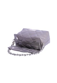 Bolso gris acolchado fabricado con material sintético, con un bolsillo con cremallera, correa de cadena y detalle del logo en el frente.