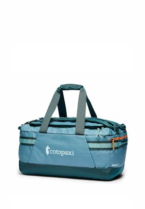 Blauwe en blauwgroene Cotopaxi Allpa 55 reiszak met grijze handvaten en meerdere ritsvakken op witte achtergrond.