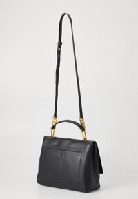 Sac à main en cuir noir avec une finition texturée, une poignée supérieure, une bandoulière ajustable et des accents en métal doré. Il dispose d'une poche avant.