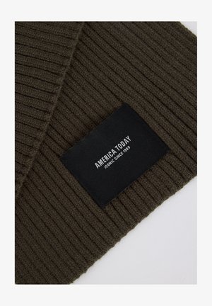 Olive green ribbed knit scarf with a black rectangular tag displaying "AMERICA TODAY" and "ICONIC SINCE 1989" in white text.