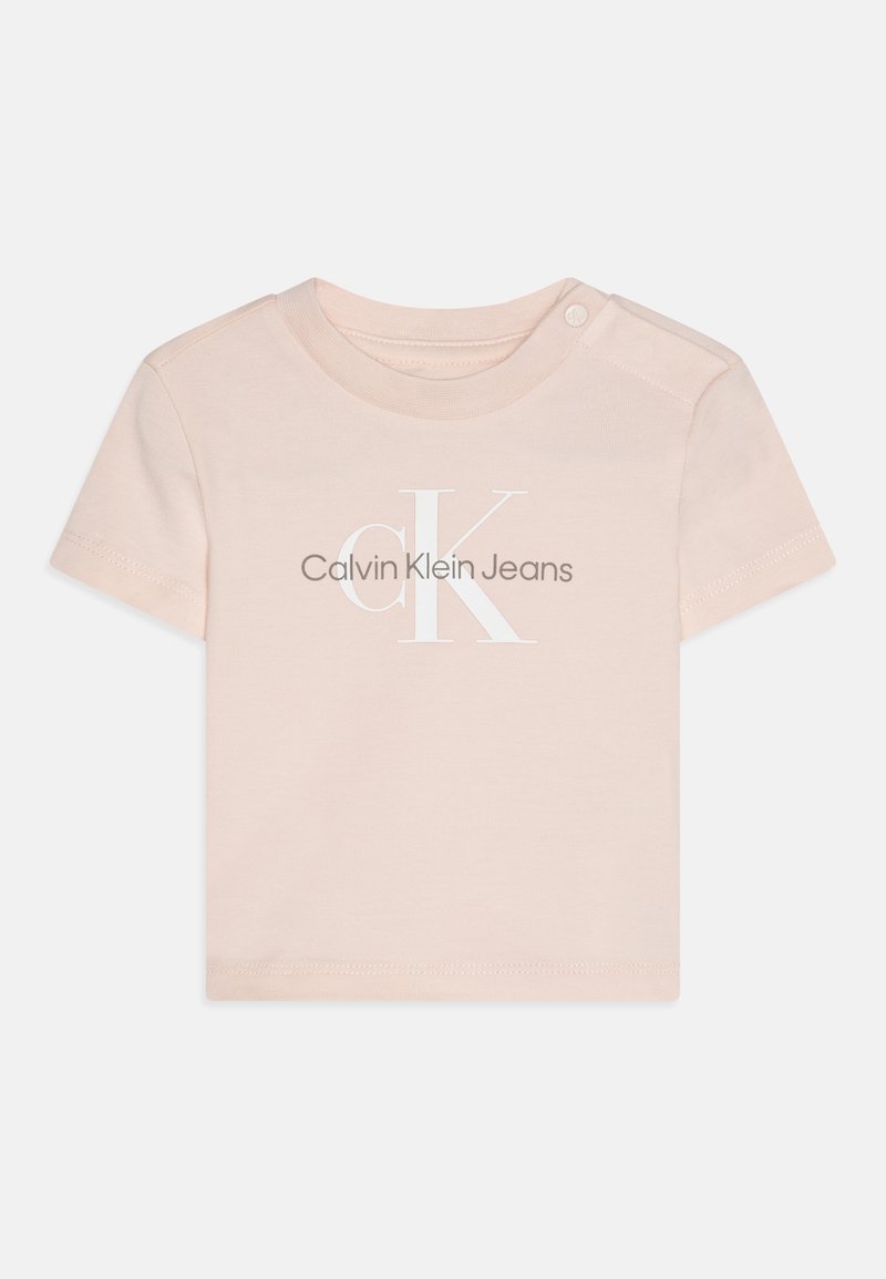 Gaiši rozā īso piedakļu T-krekls, izgatavots no mīksta kokvilnas. Izceļas ar uzrakstu "CK" baltā krāsā un "Calvin Klein Jeans" izdrukātu zem tā.