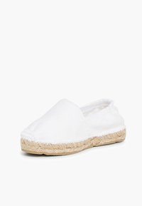 Espadrilla bianca in tela con suola piatta, dettagli in corda di juta lungo i bordi, design slip-on e cuciture minimaliste.