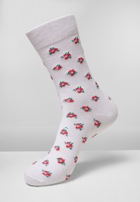 Vita bomullstrumpa med blommönster i röd och grön. Har en ribbad mudd och en jämn textur, designad för komfort och passform.