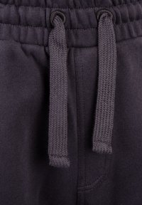 Joggers gris oscuro con una cinturilla texturizada, que cuentan con un cordón ajustable y un bolsillo lateral, fabricados en suave material de algodón.