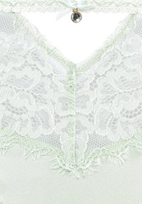 Lichtgroene kanthemd met bloemenpatronen, delicate golvende randen en een klein satijnen strikje met een decoratieve charme bij de halslijn.