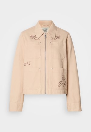 Hellbeige, cropped Jacke aus Baumwolle mit zwei Fronttaschen. Mit gestickten Details eines Einhorns und floralen Designs. Silberner Reißverschluss.