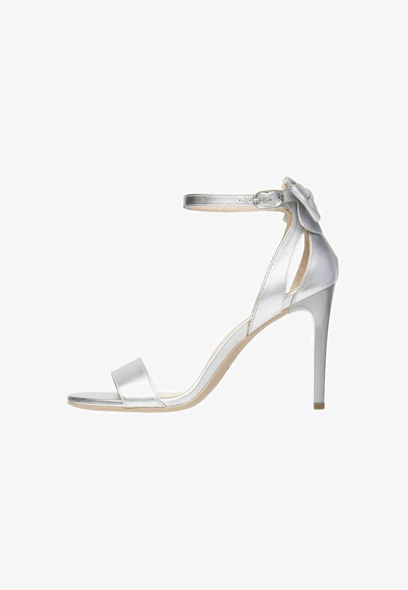 Silver high-heeled sandal with an ankle strap, featuring a smooth metallic finish, open toe design, and a decorative flower accent.