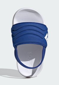 Sandalia tipo chancla azul con una correa texturizada y suela blanca, que presenta acentos acanalados y un logo de la marca en relieve en la plantilla.