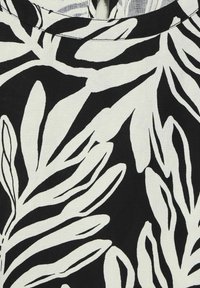 Schwarz-weißer Stoff mit einem Blattmuster. Das Design zeigt auffällige, abstrakte Blätter auf einem kontrastierenden Hintergrund, mit einer glatten Textur.