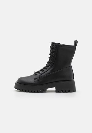 Black leather ankle boots with a round toe, lace-up front, patterned sole, and a back pull tab. Chunky sole adds height and grip.
