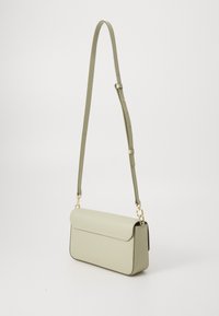 Light green leather crossbody bag with a flap closure, gold hardware, adjustable strap, and structured rectangular shape.