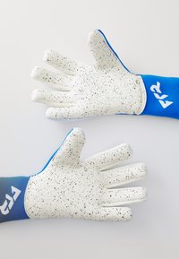 White gloves with black speckles feature a blue wrist cuff and textured grip on palm. The design allows for flexibility and durability.