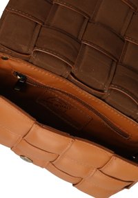Borsa in pelle marrone con texture trapuntata, caratterizzata da una base in pelle color tan e una tasca interna con zip. L'etichetta riporta "Made in Italy."
