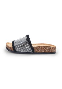 Sandal sa platformom od plute, s gornjim dijelom ukrašenim crnim i srebrnim perlicama, koji ima resice i teksturiranu podlogu za bolju prionuće.